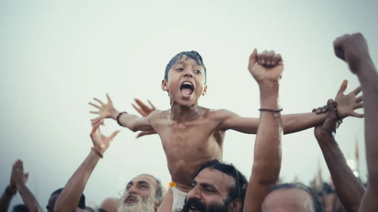 A boy lifted above the Mahakumbh crowd, a festival frame shot by Eknetra